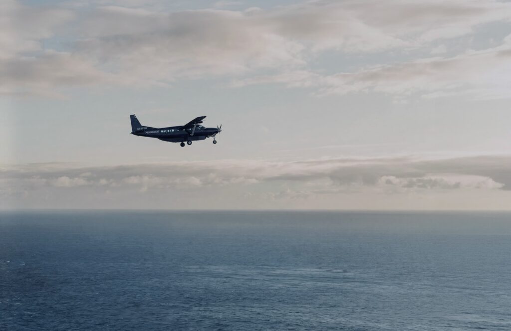 A Mokulele Cessna Grand Caravan in flight over open ocean between the Hawaiian Islands